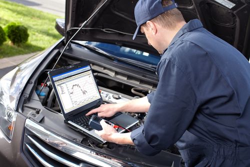 Mechanic performing engine diagnostics test