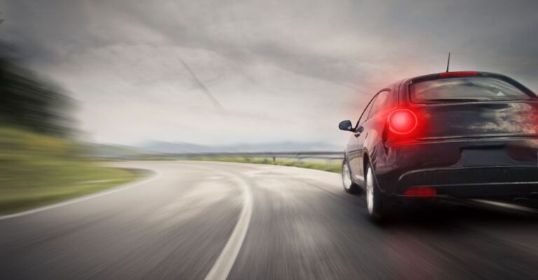 Car driving fast down a road
